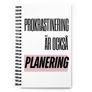Notebook med texten "Prokrastinering är också planering" – spiralbunden med prickade sidor.
