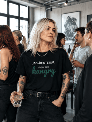 Blond kvinna i svart oversize t-shirt med roligt citat, "Jag är inte sur, jag är bara hangry".