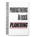 Notebook med texten "Prokrastinering är också planering" – spiralbunden med prickade sidor.